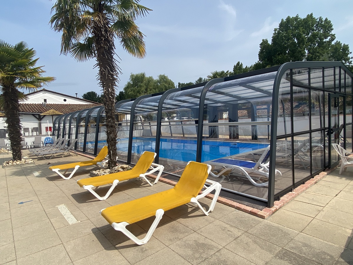 piscine couverte vue et plages extérieures avec transats